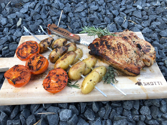 Veal chops with grilled tomatoes and rosemary potato skewers